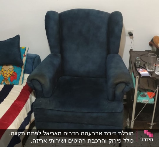 כורסה כחולה ליד שולחן קטן עם חפצים